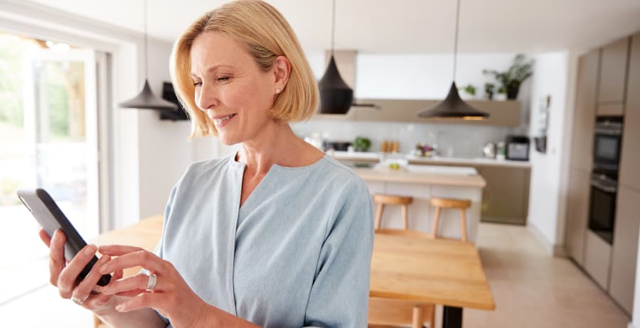 Woman using a cell phone in a room filled with sunlight
